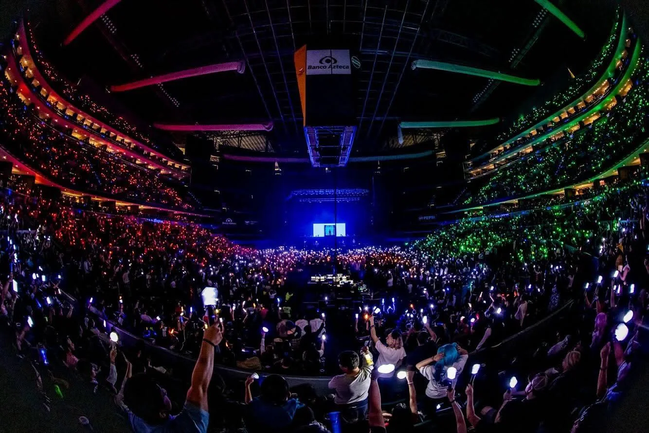 Público llenando una arena durante un evento, visto desde la parte posterior del recinto.